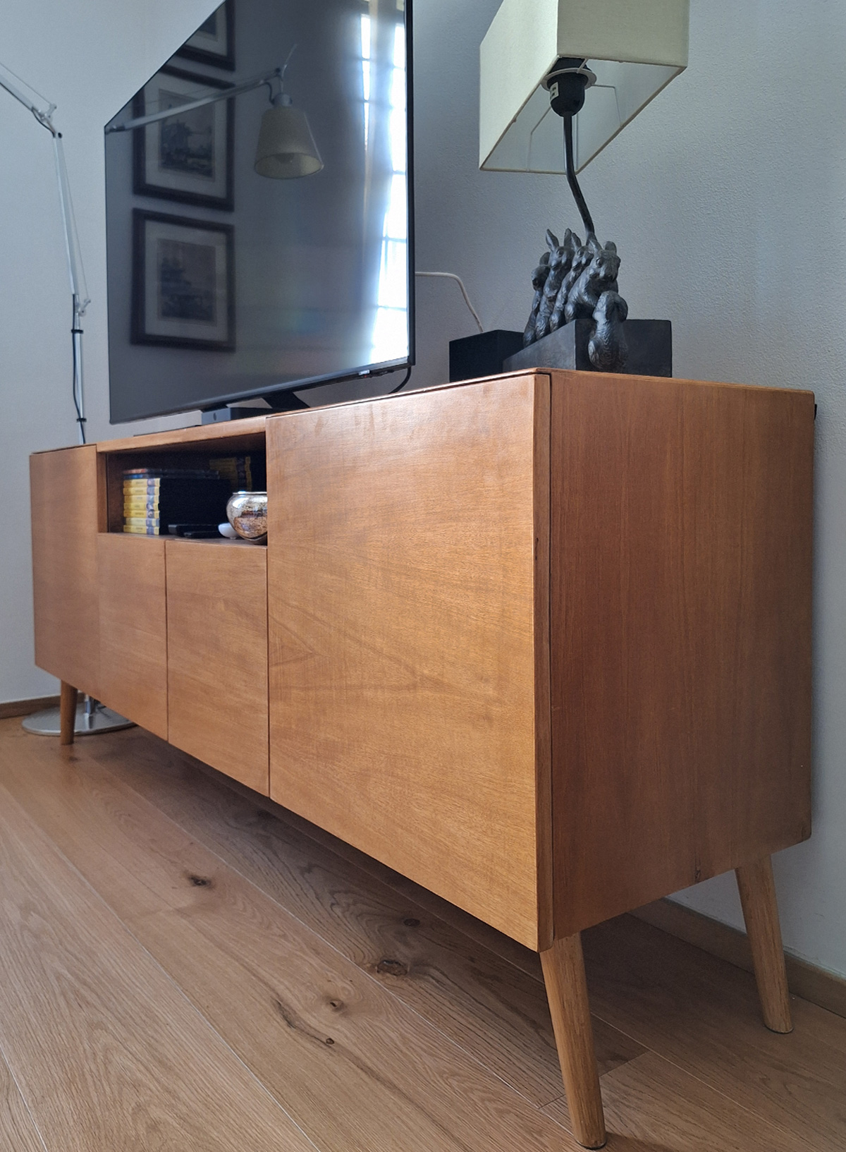 Mobile TV in legno su misura con ante lisce e piedini inclinati, stile moderno artigianale