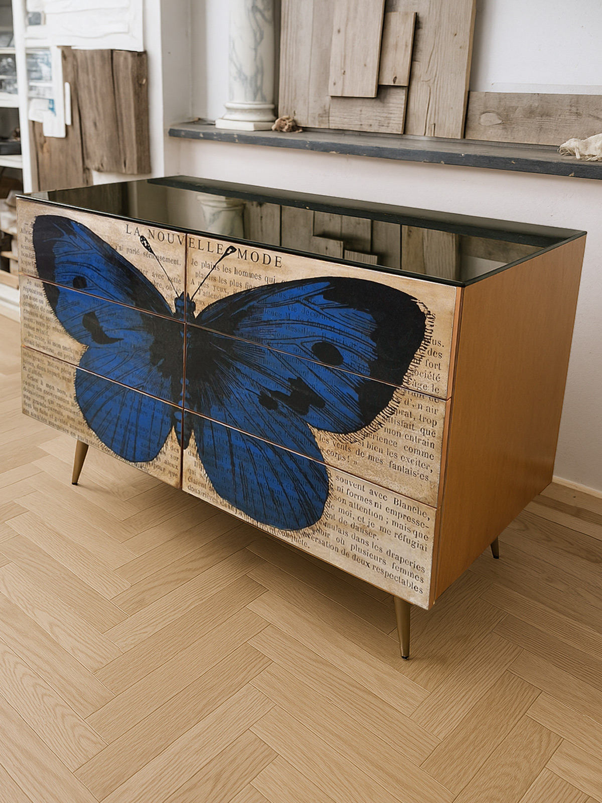 Cassettiera artigianale in legno di noce con decorazione a farfalla blu, inserti in ottone e piano in specchio nero