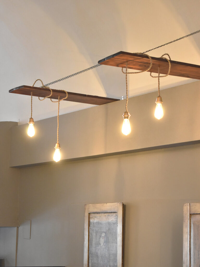 Lampadario sospeso su misura ad Arezzo con tavole in legno, catene ottonate e filo in corda vintage – complemento d’arredo artigianale