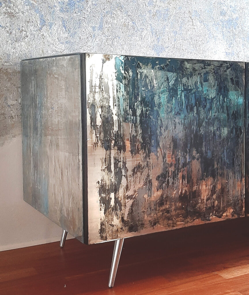 Grande madia moderna a quattro moduli con ante e cassetti rivestiti in specchio anticato, su pavimento in legno chiaro