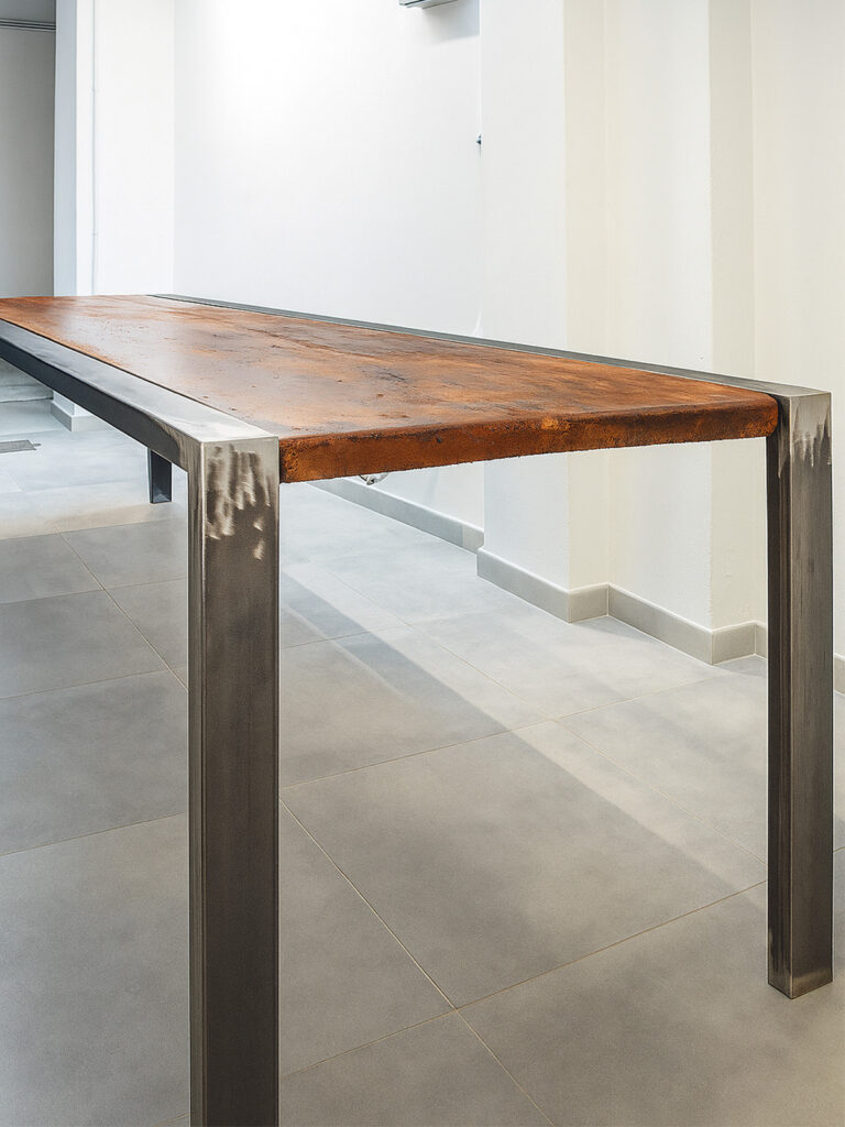 tavolo artigianale con piano in legno e gambe in ferro spazzolato in stile industriale minimale