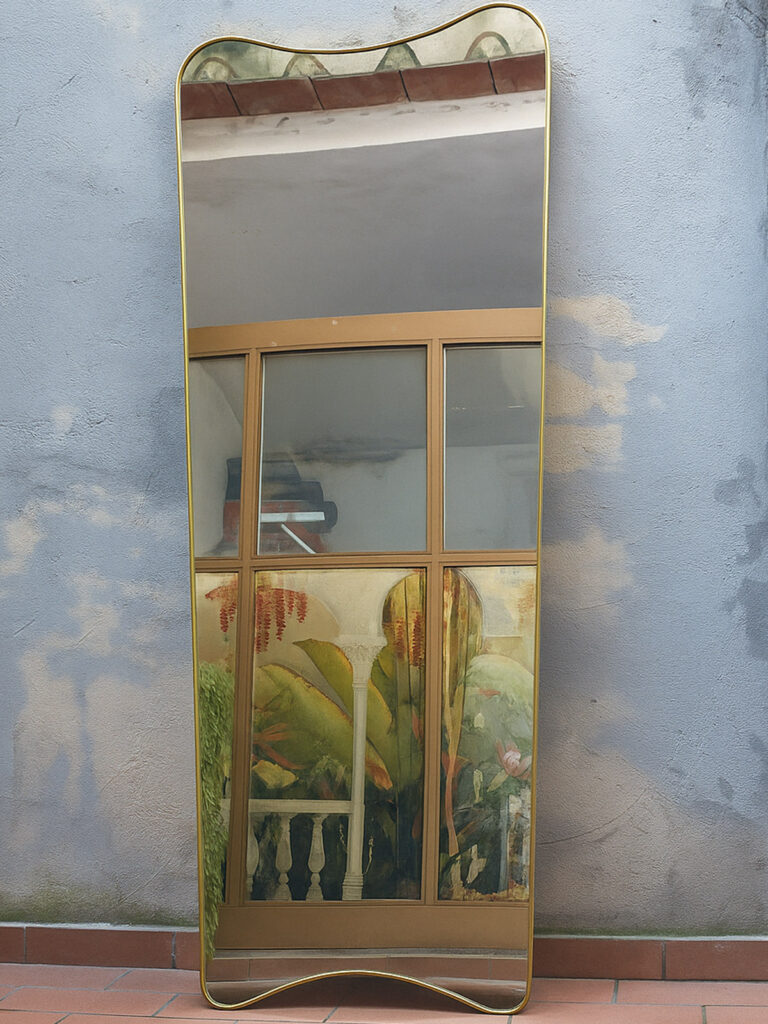 Specchio in ottone curvato a mano con cornice sinuosa anni ’70, arredamento su misura artigianale Bologna