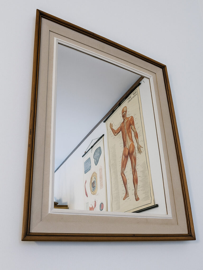 Specchio con cornice in legno modanata, finitura verde salvia e oro, design classico contemporaneo.